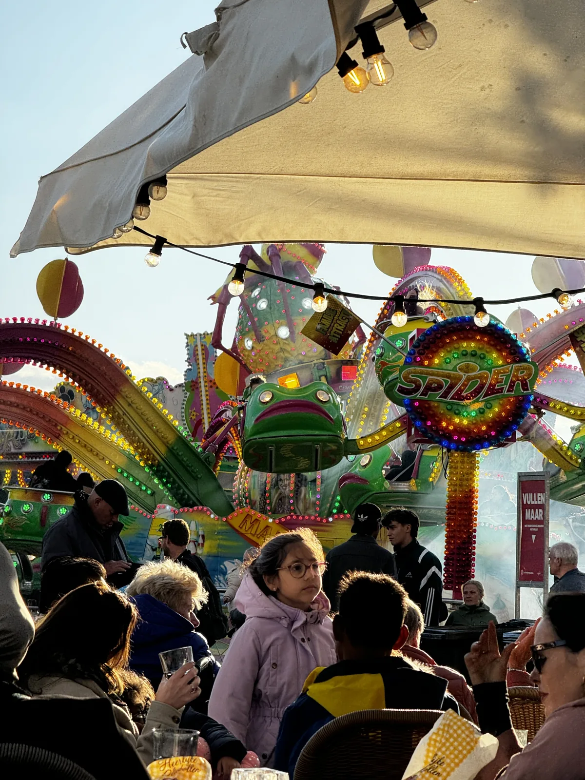 Visitors at a colourful carousel on the Leidens Ontzet funfair in the centre of Leiden